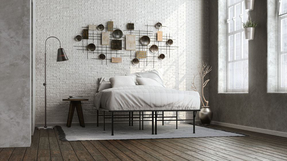 Minimalist bedroom with a tall metal bed frame, white bedding, a textured white brick wall, and modern wall art.