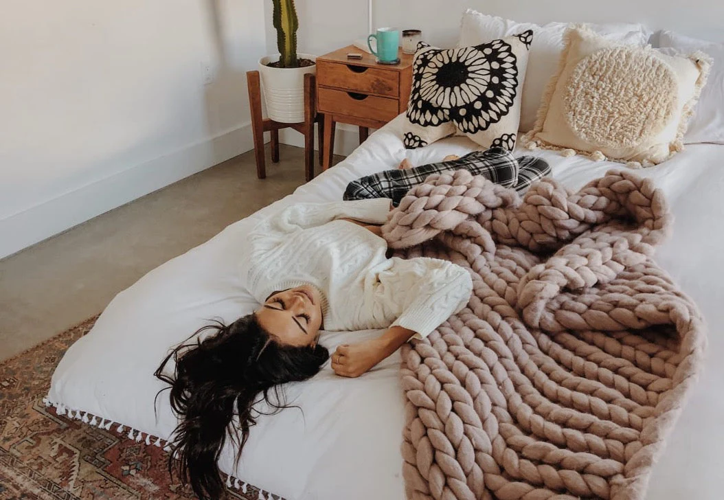 Women laying on a Zinus bed in a warm and cozy bedroom.