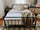 Modern rustic bedroom with black metal bed frame, white bedding, tan blanket, and neutral pillows; wood nightstands, woven decor, and soft natural light create a cozy retreat