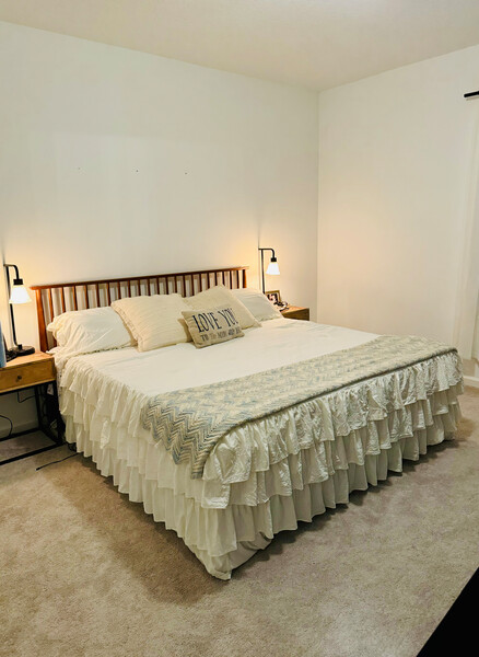 Zinus wood platform bed with slatted headboard in a minimalist bedroom, styled with white ruffled bedding and accent pillows, highlighting sturdy mattress support, timeless design, and a cozy, uncluttered sleep space with warm bedside lighting