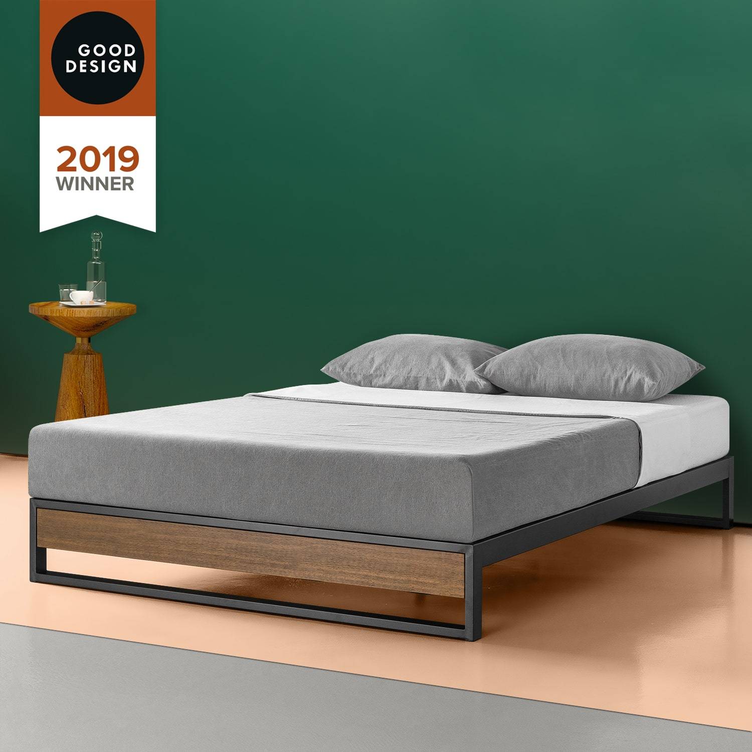Modern platform bed with gray bedding and a wooden-accent frame, set against a green wall with a Good Design 2019 award badge.