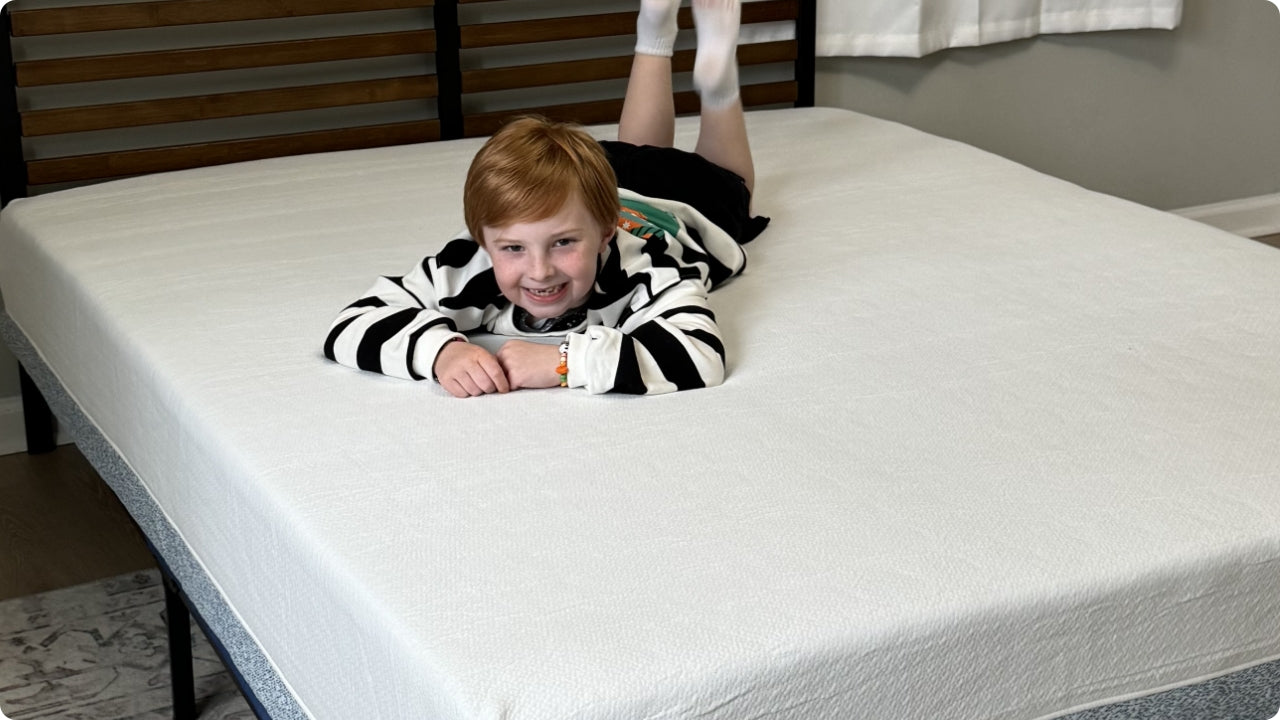 Child lying comfortably on a white memory foam mattress in a bedroom, demonstrating a soft, supportive surface suitable for everyday use and family-friendly comfort.
