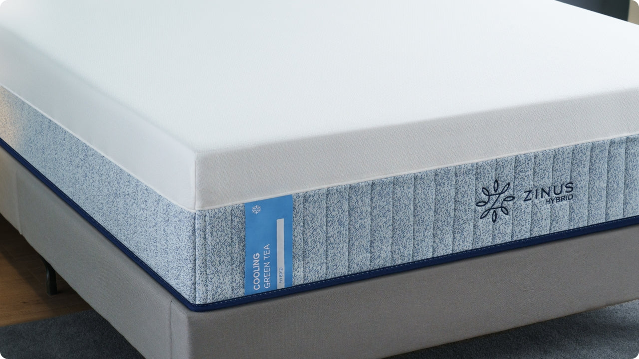 Cooling green tea hybrid mattress with a smooth white top and blue-speckled side panel featuring a cooling label and Zinus Hybrid branding, highlighting supportive foam and coil construction designed for cooler, comfortable sleep