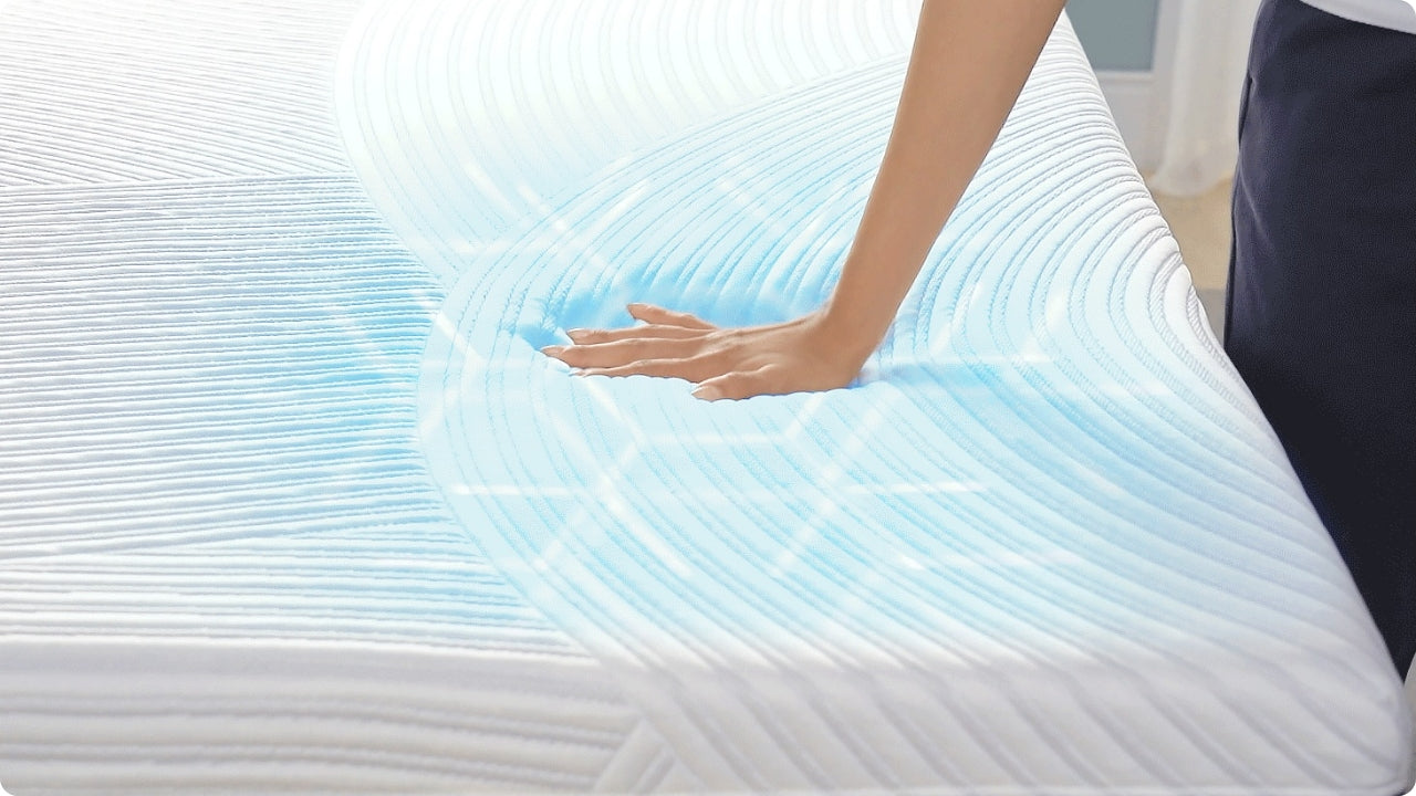 Hand sinking into contoured mattress surface with blue cooling response illustrated around the pressure point.