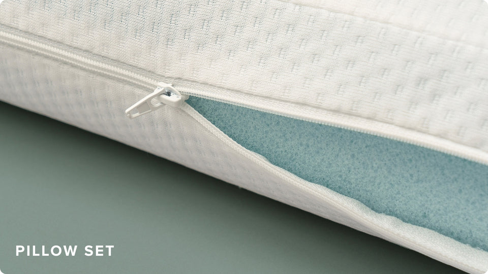 Close-up of white memory foam pillow with zippered cover slightly open to show blue cooling foam interior, labeled 'Pillow Set' in corner.