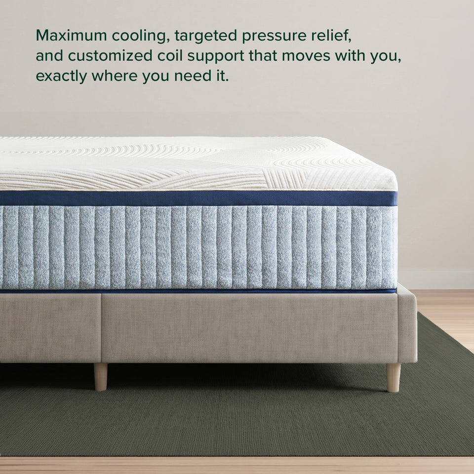 Zinus Balanced Comfort Luxe Hybrid Mattress, side view close-up of the quilted white cover and channel-quilted light blue woven base on an upholstered platform bed, with on-image text reading: 'Maximum cooling, targeted pressure relief, and customized coil support that moves with you