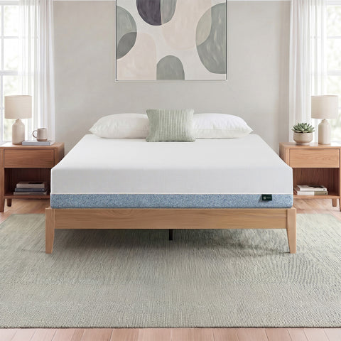 Zinus Original Green Tea Memory Foam Mattress, Queen, on light wood platform bed frame in bright bedroom with white and sage pillows, matching nightstands, lamps, books, and a succulent plant.
