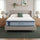 Zinus Ultra Cooling Green Tea Hybrid Mattress, Queen, on upholstered bed frame in bright bedroom with white pillows, sage cushion, plants, wall shelf decor, and matching nightstands with lamps.