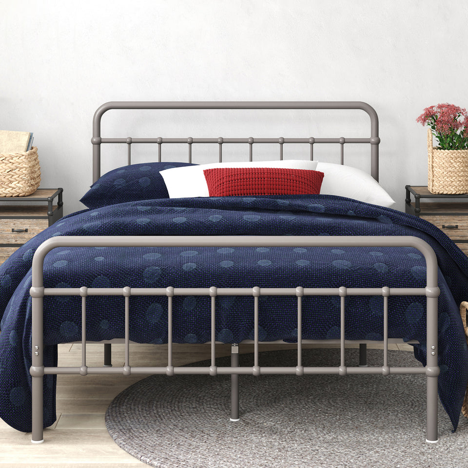 Styled bedroom featuring Zinus metal bed frame with headboard, dressed in blue bedding with decorative pillows and wicker storage basket beneath. Sturdy steel frame adds modern farmhouse charm while supporting queen or full mattresses with underbed storage space.