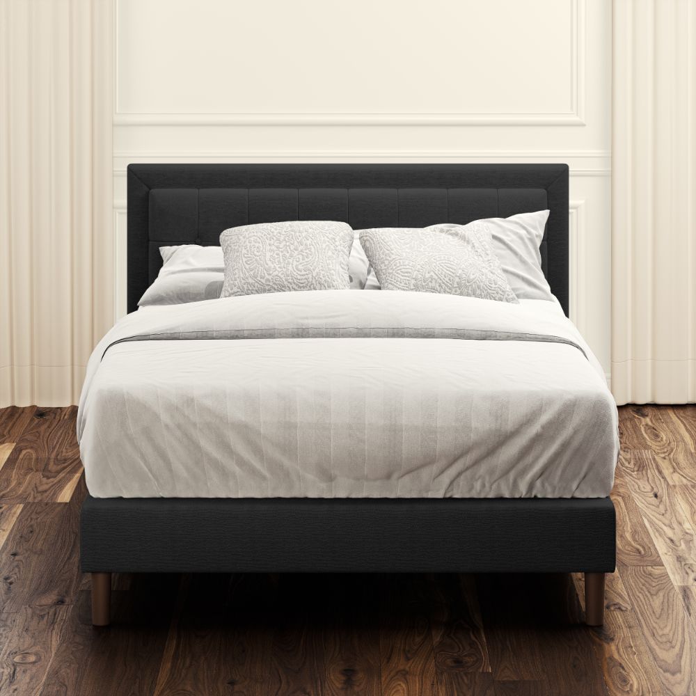 Front view of Zinus Dachelle Upholstered Platform Bed Frame in dark gray with square tufted headboard. Styled with neutral bedding in a modern bedroom, this sturdy platform bed provides lasting mattress support and elegant design.