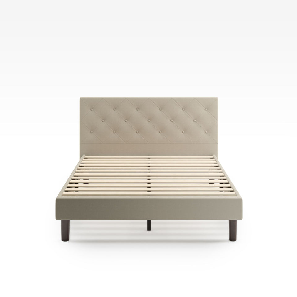 Zinus Shalini Upholstered Platform Bed Frame in a beige velvet finish, shown from the front without a mattress. Features a button-tufted headboard, wooden slats for strong mattress support, and a modern upholstered design that fits any bedroom style