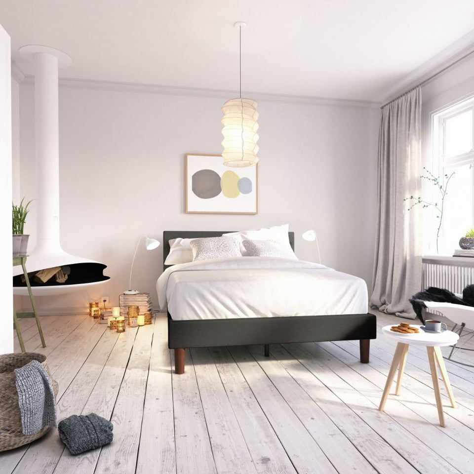 Zinus Shalini Upholstered Platform Bed Frame in a bright modern bedroom with white flooring and cozy décor. The dark gray tufted headboard pairs with sturdy slats for reliable mattress support, combining function, durability, and timeless upholstered style.
