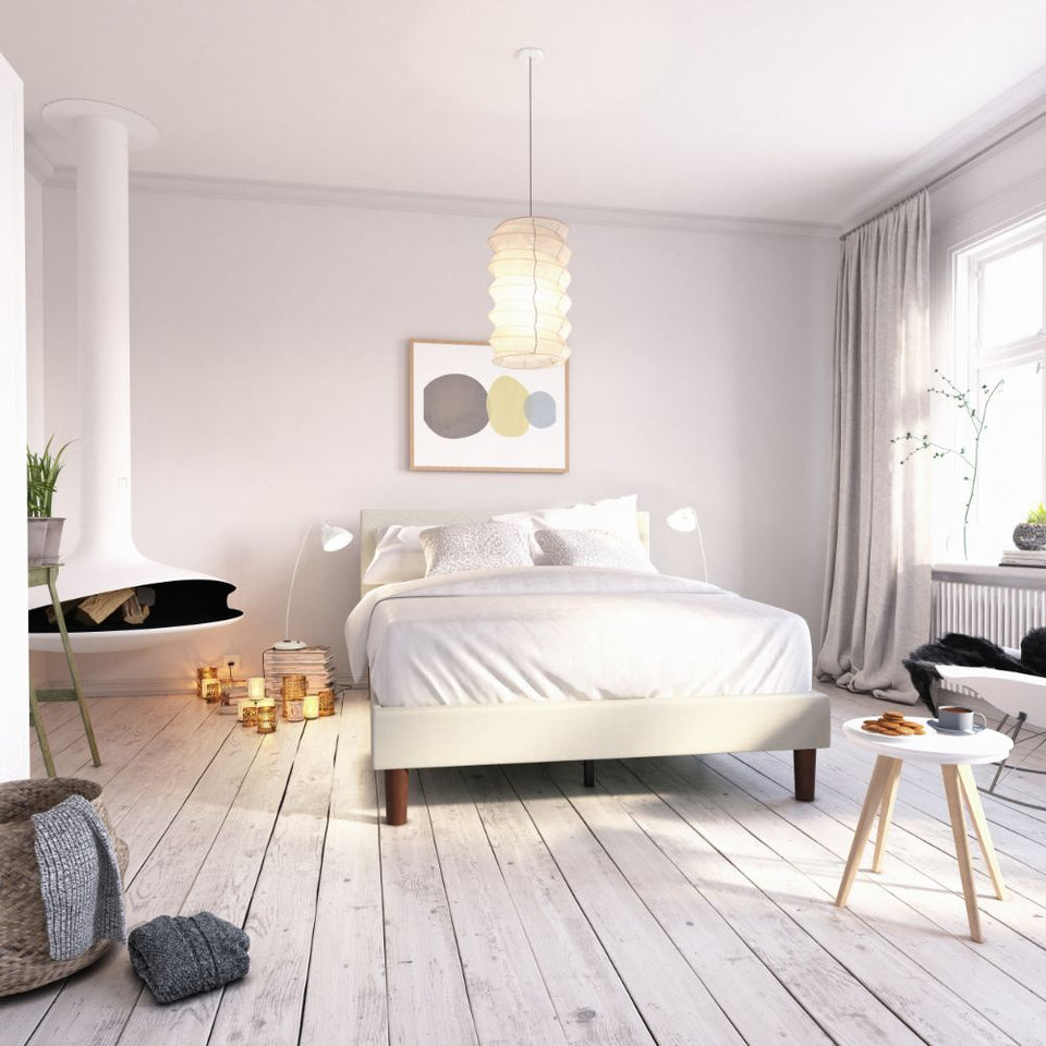 Zinus Shalini Upholstered Platform Bed Frame in a bright modern bedroom with white flooring and cozy décor. The light white tufted headboard pairs with sturdy slats for reliable mattress support, combining function, durability, and timeless upholstered style.