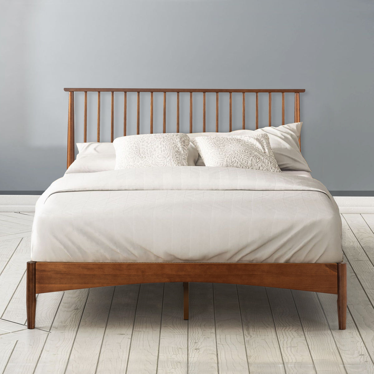 Zinus Linda Wood Platform Bed Frame shown styled with white bedding against a gray wall. Rich walnut wood frame and tall slatted headboard create a warm mid-century centerpiece. Strong wood slats provide sturdy mattress support with lasting comfort and simple modern design
